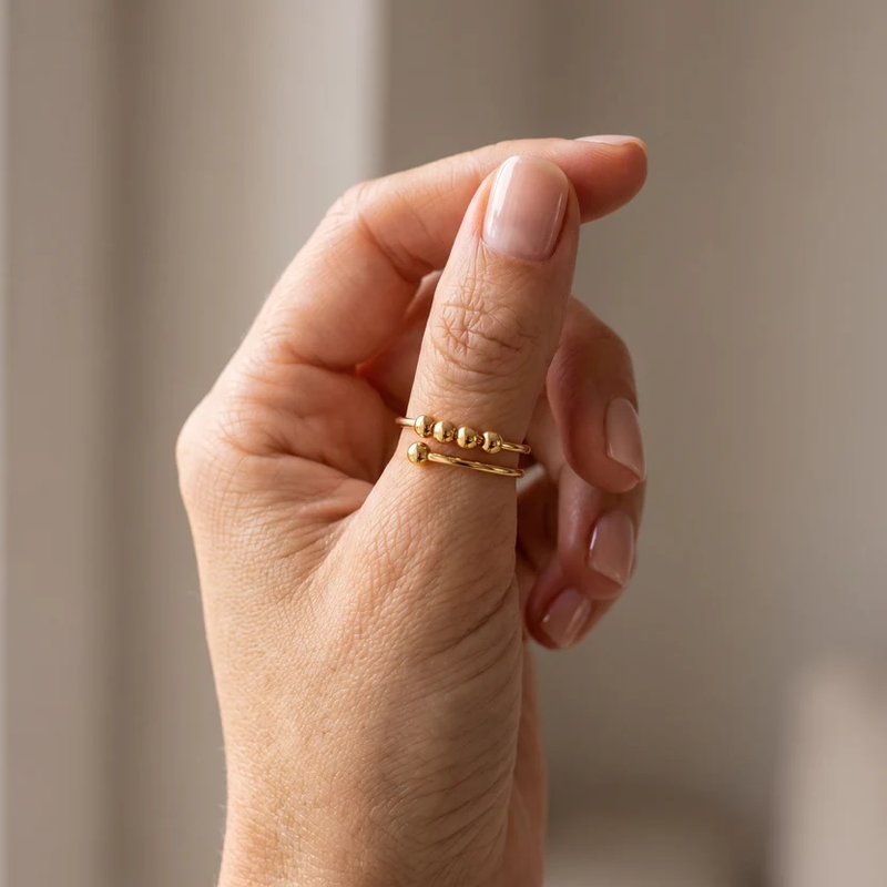 Cuff Ring with four beads, in gold, worn on the hand