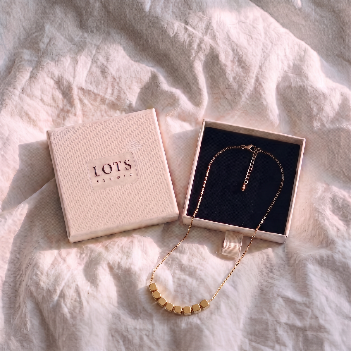 Block Necklace in the LOTS Studio gift box, its eight blocks on a fine chain