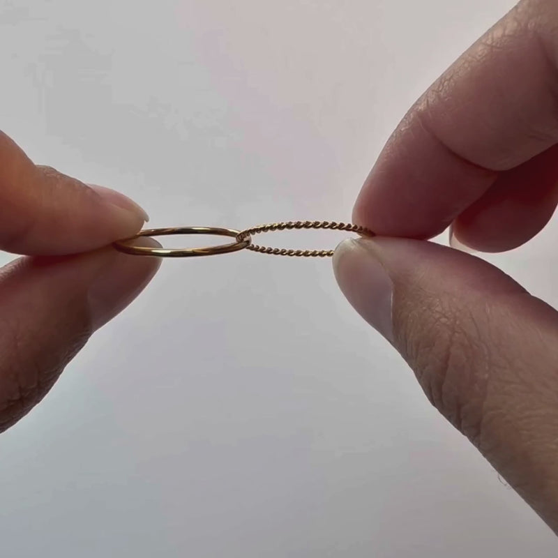 Thread Ring in silver, the rope band rolling under a thumb