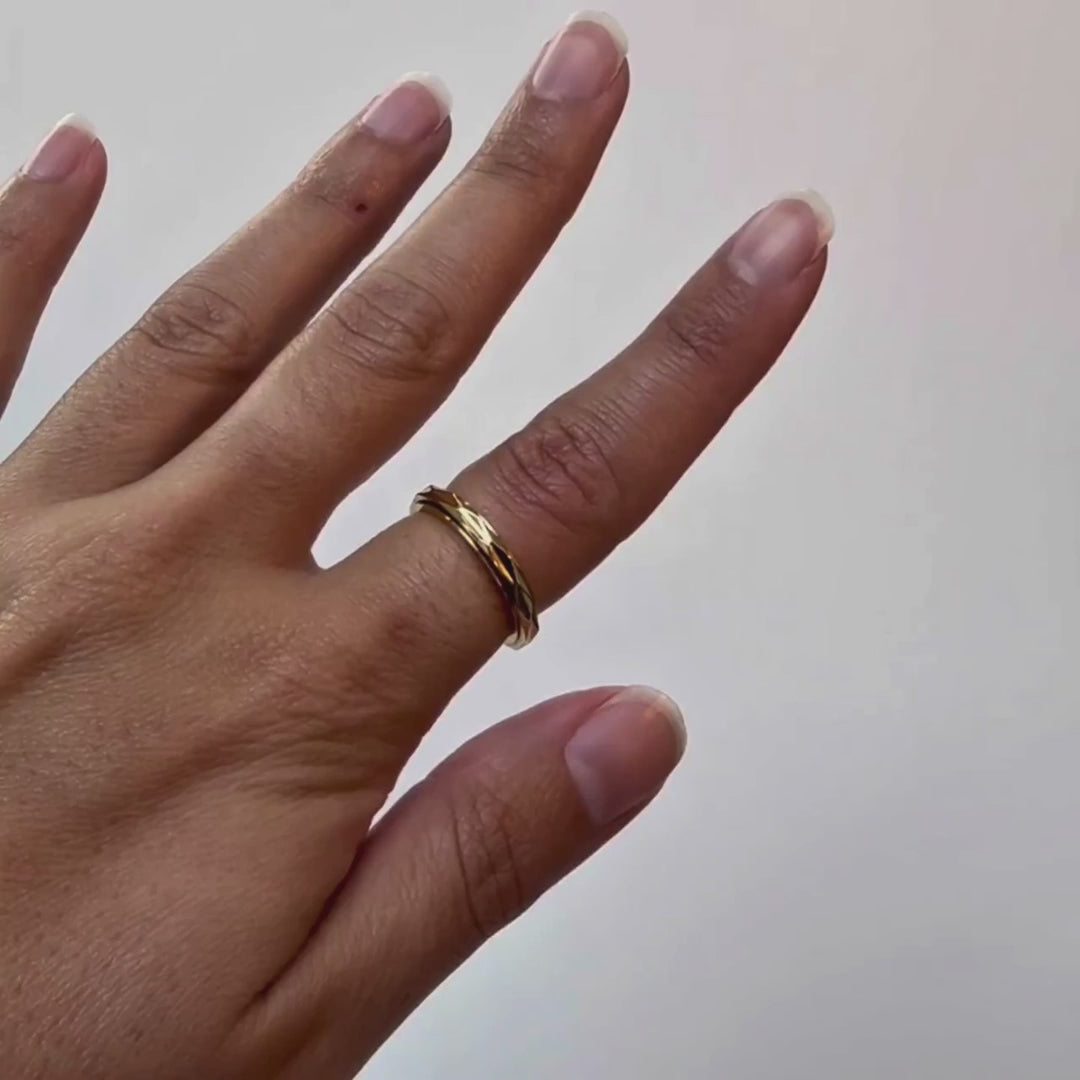 Spinner Ring in gold, the outer band turning under a thumb