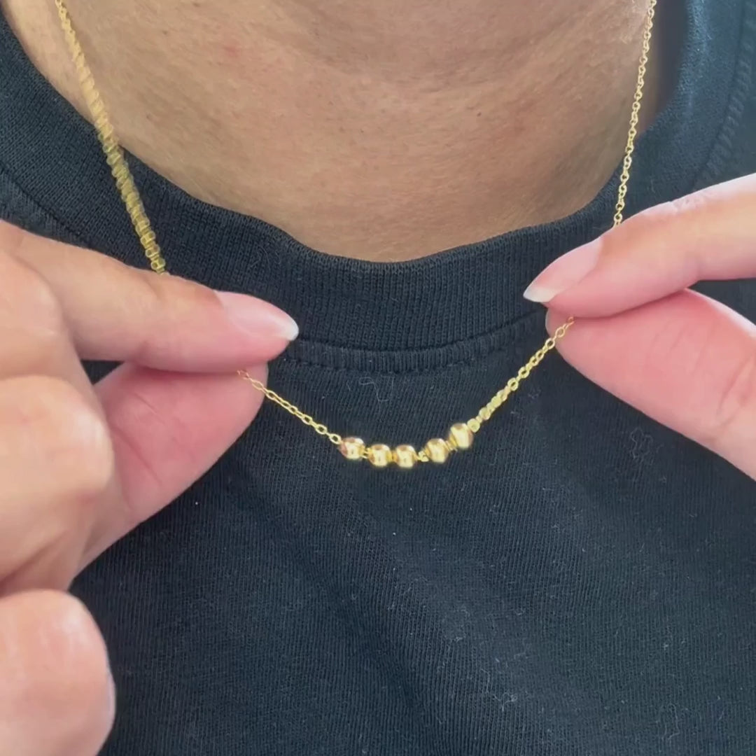 Slider Necklace in gold, the beads sliding along the chain